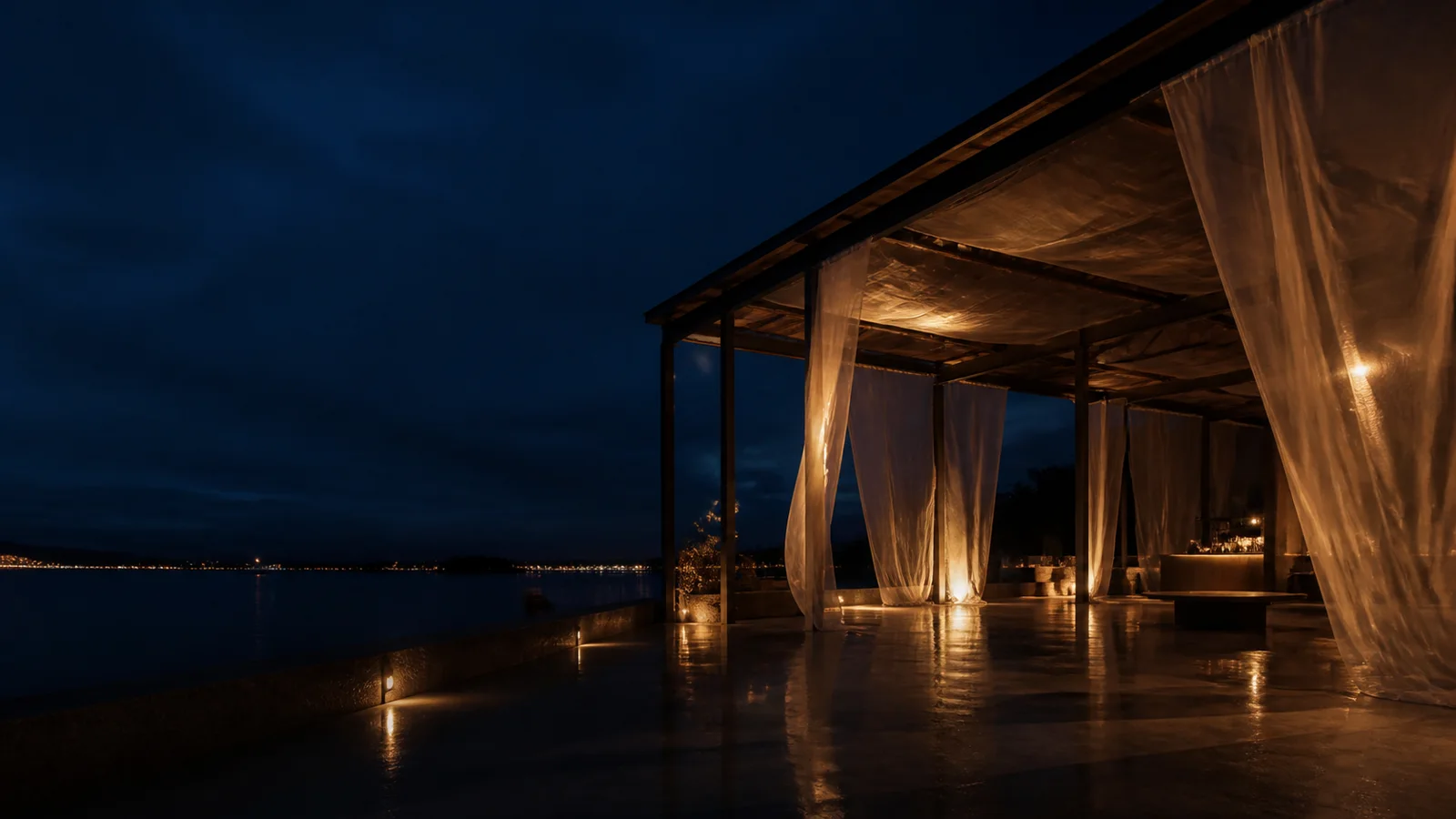 Pavilhão fictício iluminado à noite junto a uma baía